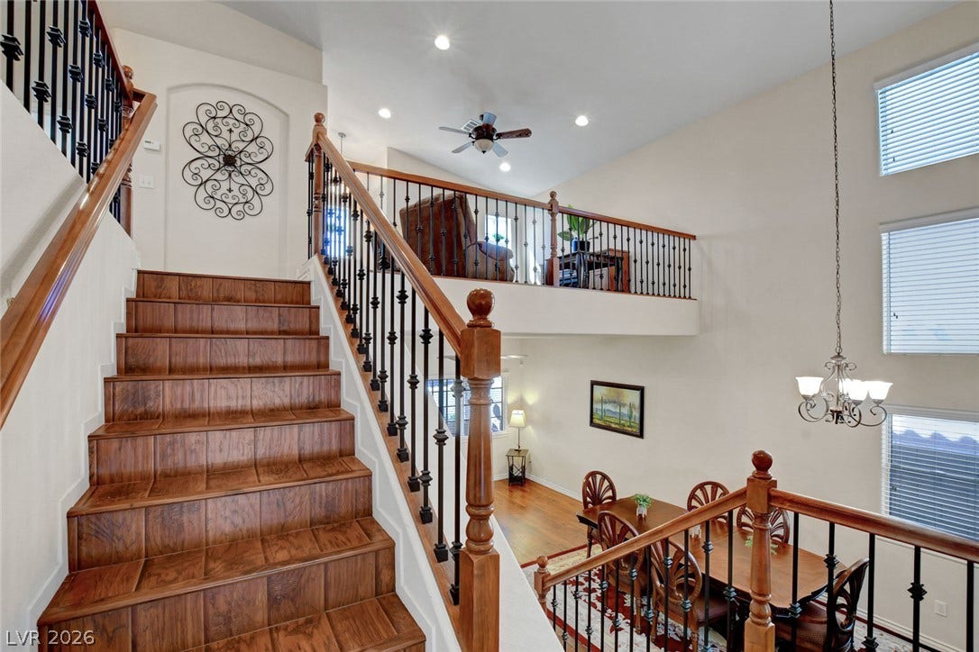 5508 Meridian Rain Street, North Las Vegas, NV 89031 Rich wood stairs ascend past towering windows and overlooking balconies.