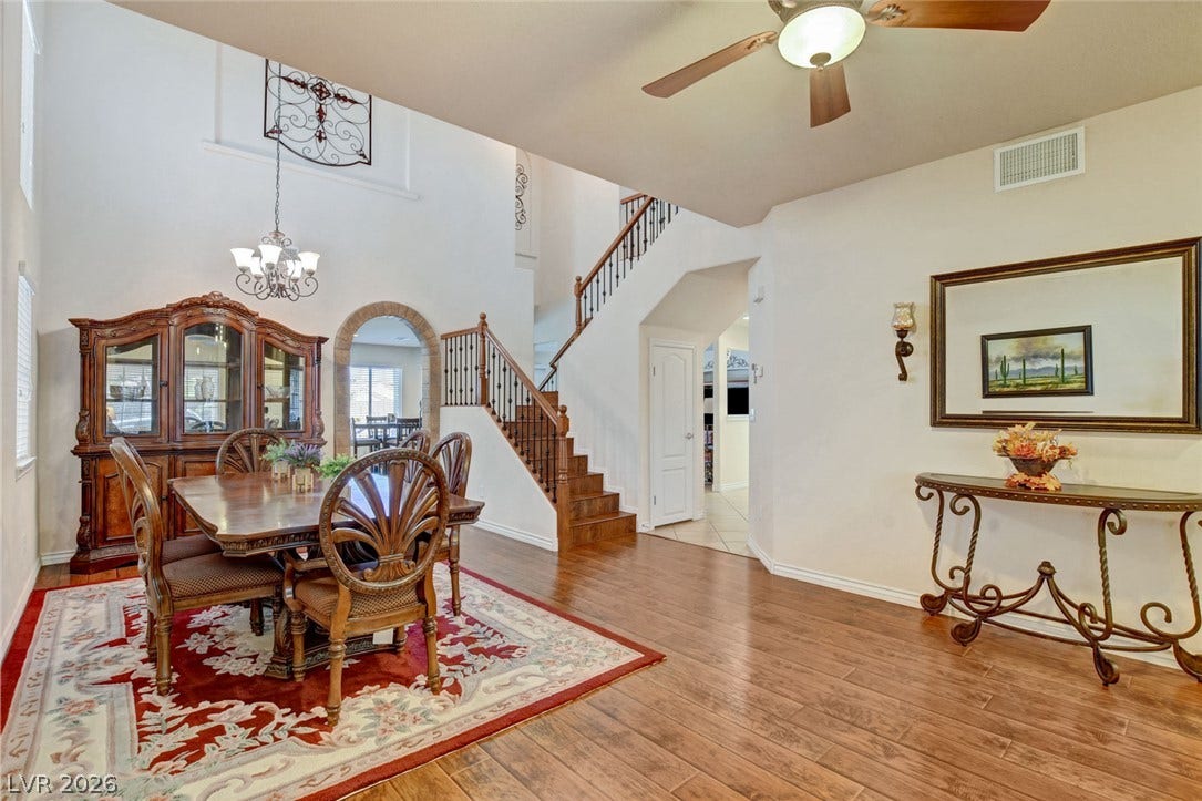 5508 Meridian Rain Street, North Las Vegas, NV 89031 An open dining area features high ceilings, wood-look flooring, and a classic wooden staircase.