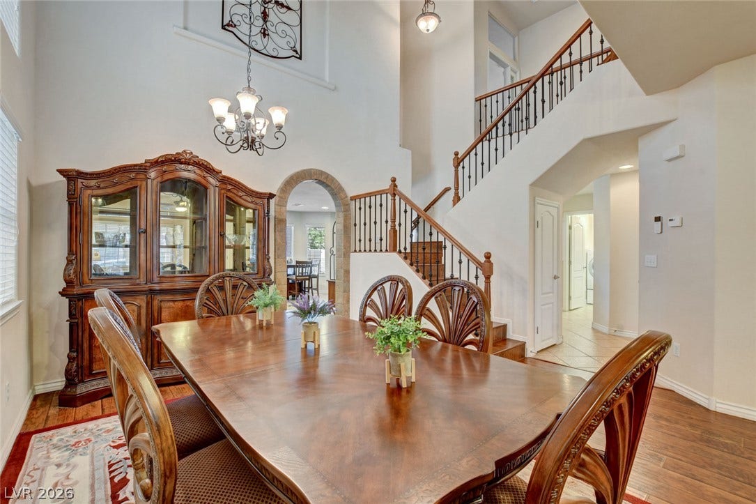 5508 Meridian Rain Street, North Las Vegas, NV 89031 Dramatic high ceilings and a classic staircase frame this elegant formal dining room space.