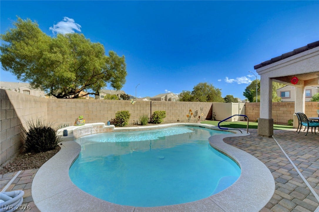 5508 Meridian Rain Street, North Las Vegas, NV 89031 An inviting backyard oasis features a curved swimming pool and a paved patio area.