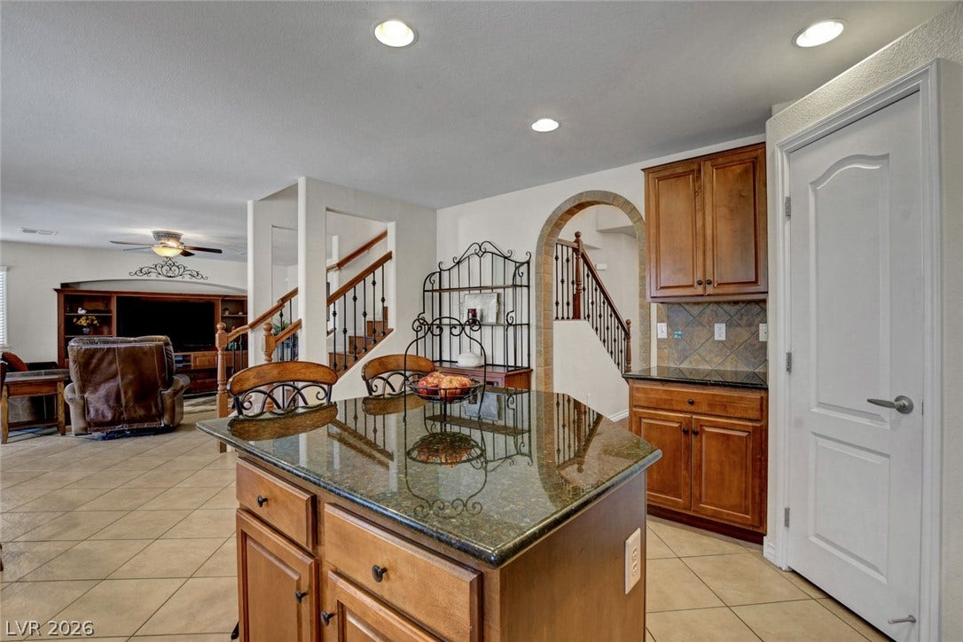5508 Meridian Rain Street, North Las Vegas, NV 89031 Polished granite countertops and warm wood cabinetry anchor this functional open kitchen space.