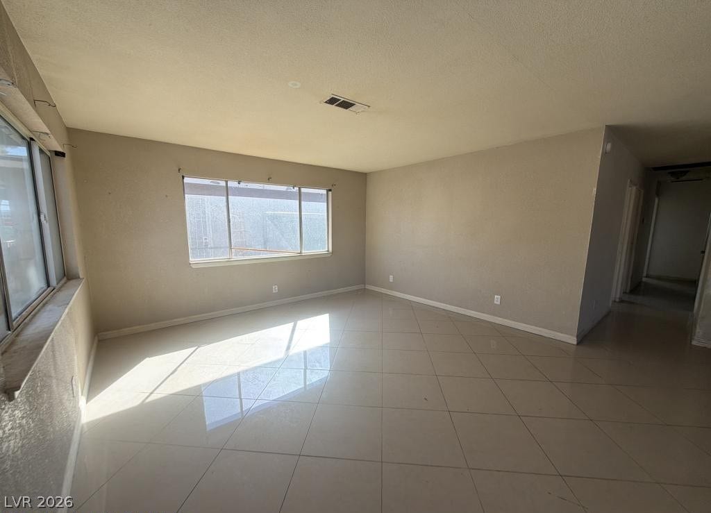 851 W Carey Avenue, North Las Vegas, NV 89030 Gleaming tile floors reflect abundant natural light in this open-concept living area.