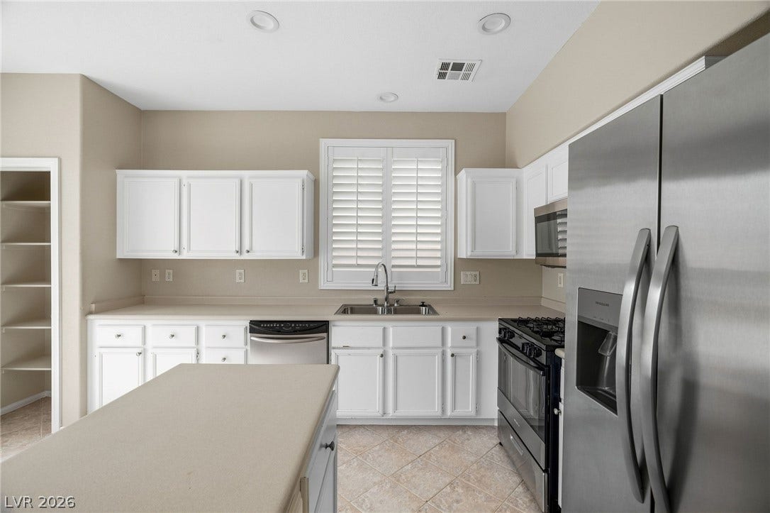 2381 Predera Avenue, Henderson, NV 89052 White cabinetry and tile flooring complement the spacious cooking area and central island.