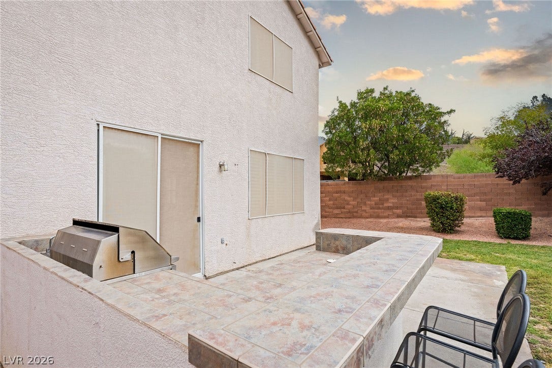 2381 Predera Avenue, Henderson, NV 89052 Tiled outdoor kitchen surfaces extend alongside sliding glass door entryways.