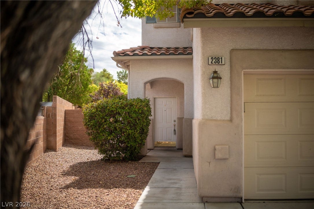 2381 Predera Avenue, Henderson, NV 89052 A concrete walkway leads to the covered front entry of this stucco home.