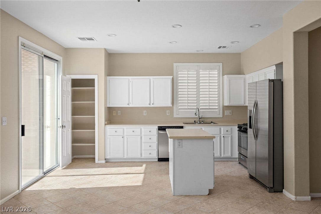 2381 Predera Avenue, Henderson, NV 89052 Tile flooring and bright cabinetry define this kitchen space featuring a central prep island.