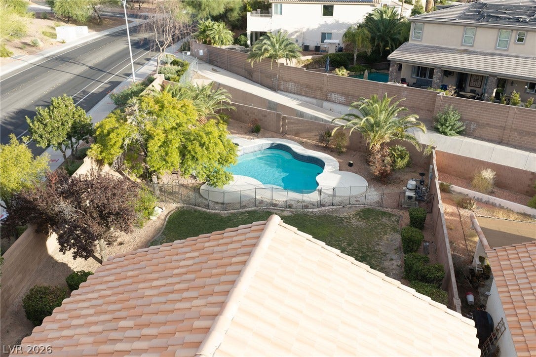 2381 Predera Avenue, Henderson, NV 89052 An inviting backyard oasis features a sparkling swimming pool enclosed by security fencing.