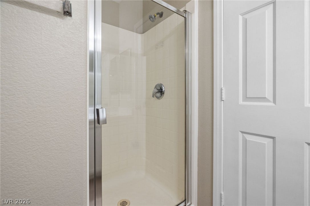 2381 Predera Avenue, Henderson, NV 89052 Clean lines and a glass door define this bright, tiled walk-in shower.