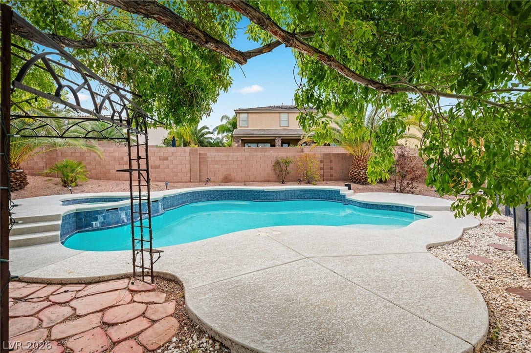 2381 Predera Avenue, Henderson, NV 89052 A sparkling in-ground pool is framed by mature trees and a privacy block wall.