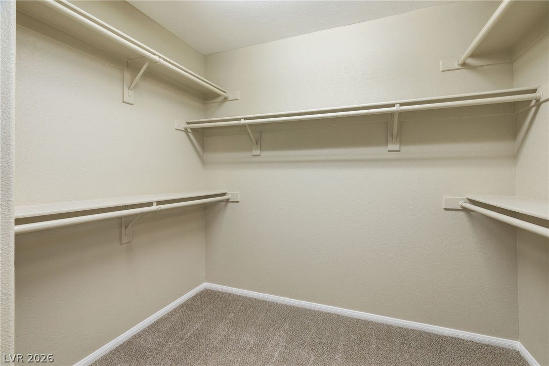 2381 Predera Avenue, Henderson, NV 89052 Ample built-in shelving and hanging rods maximize storage within this carpeted walk-in closet.