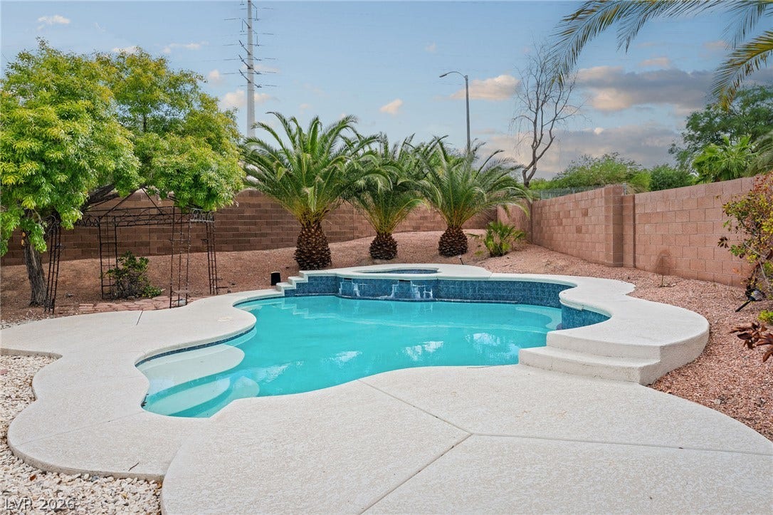 2381 Predera Avenue, Henderson, NV 89052 A sparkling freeform swimming pool is anchored by a concrete deck and a block wall border.