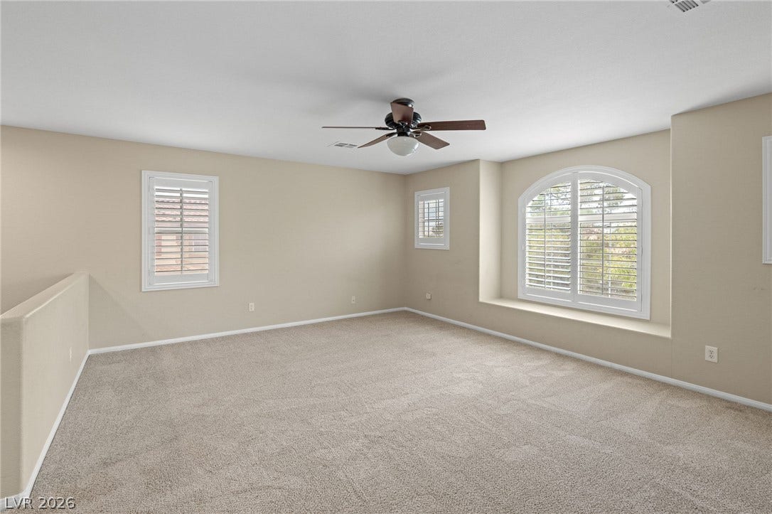 2381 Predera Avenue, Henderson, NV 89052 An arched window alcove and plush carpeting define this versatile upper-level loft space.