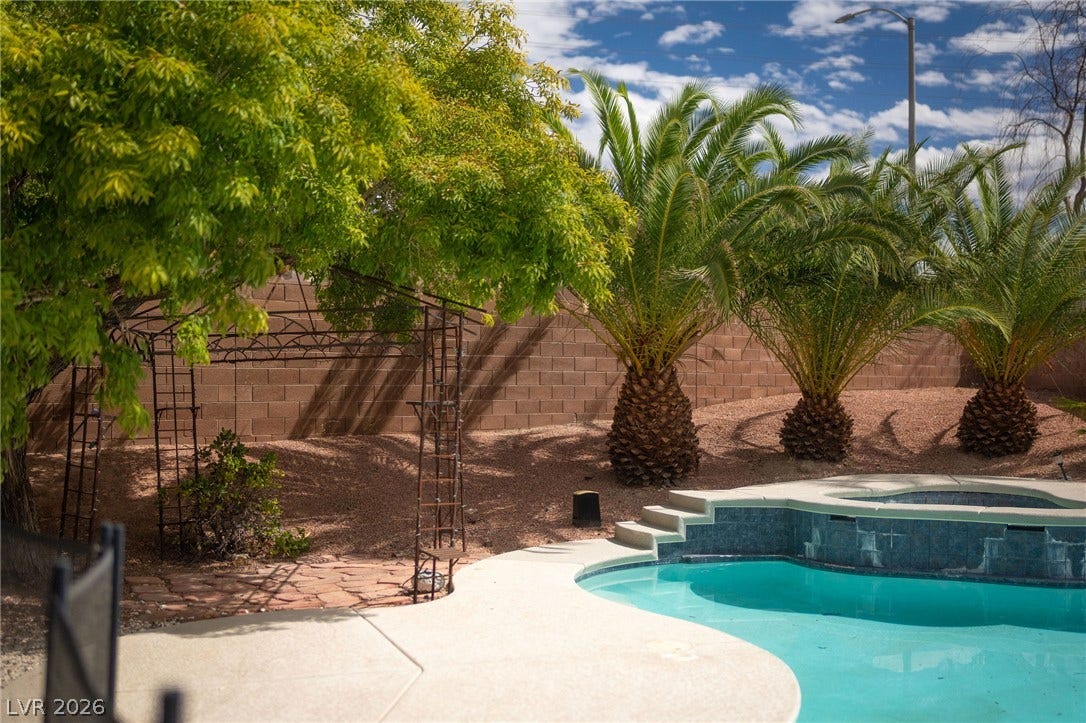 2381 Predera Avenue, Henderson, NV 89052 Lush palms and a stone wall frame the sparkling pool in this private backyard.