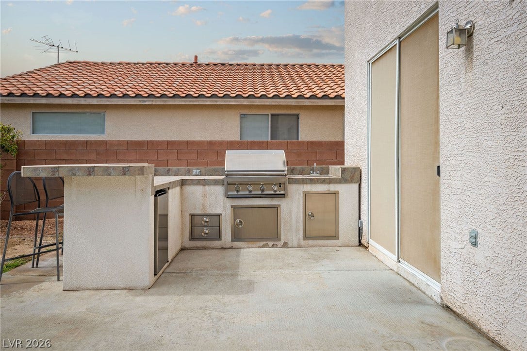 2381 Predera Avenue, Henderson, NV 89052 Concrete patio features an integrated outdoor kitchen with a built-in grill and tile counters.