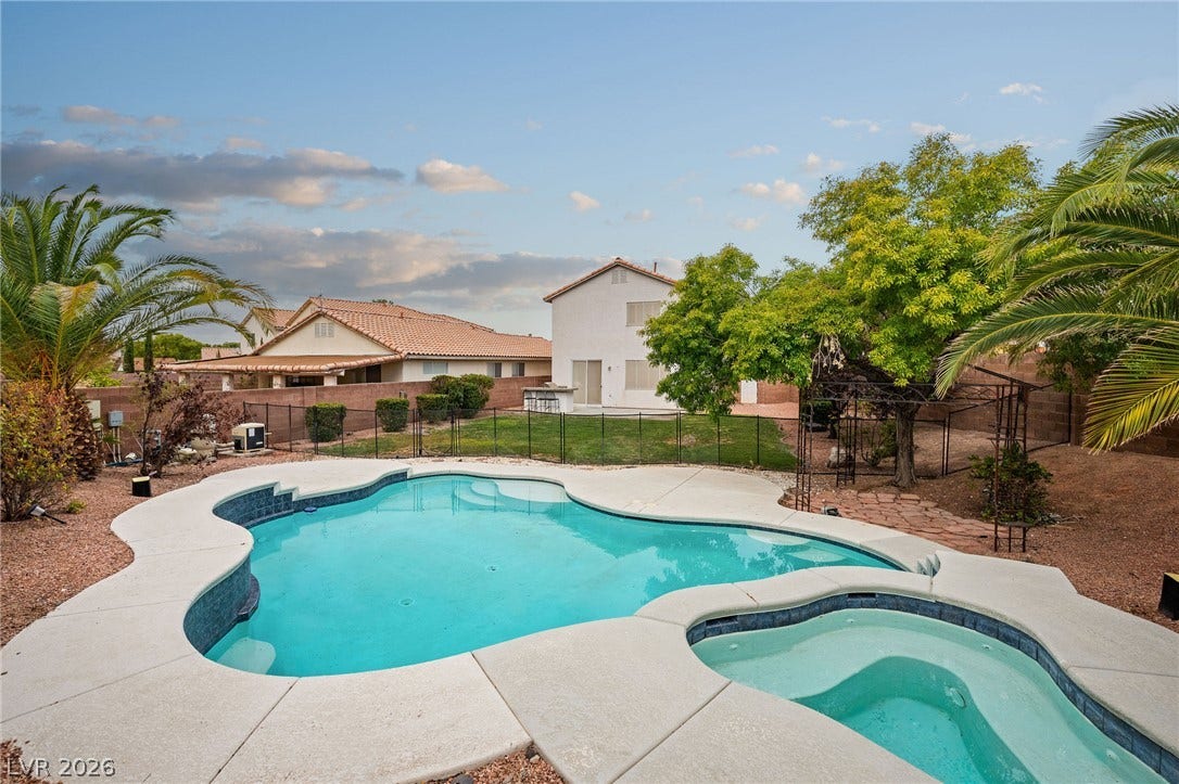 2381 Predera Avenue, Henderson, NV 89052 An inviting backyard oasis features a curved swimming pool alongside a matching integrated spa.