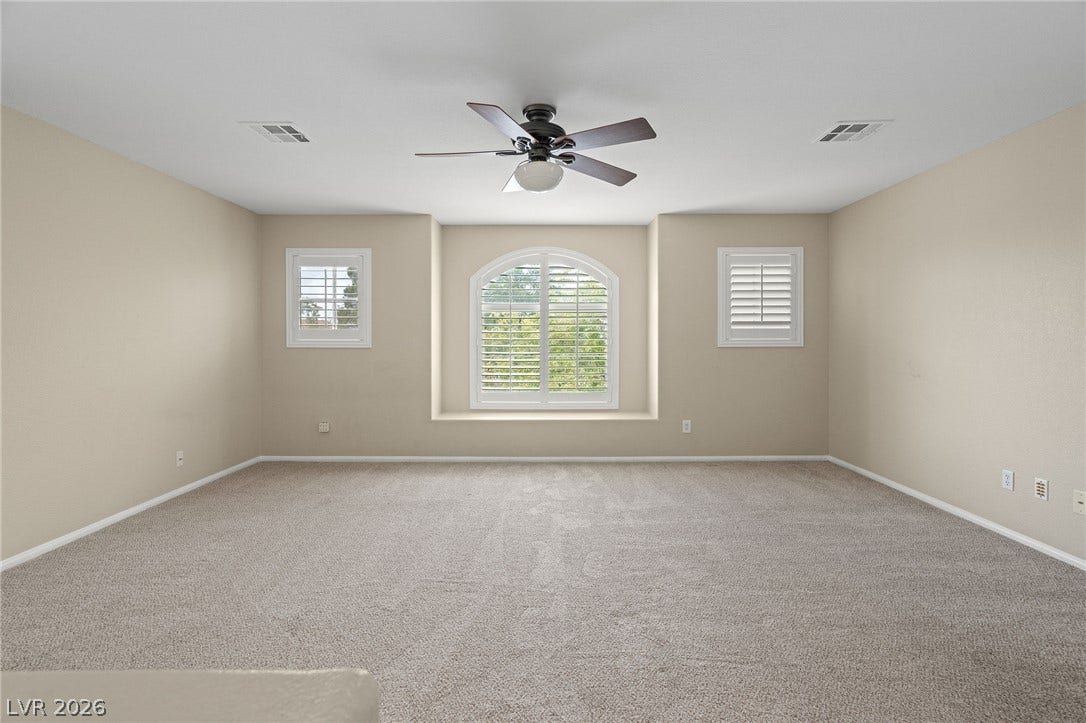 2381 Predera Avenue, Henderson, NV 89052 Plush carpeting anchors this versatile room detailed with classic arched window framing and plantation shutters.