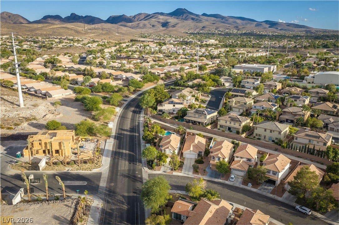 2381 Predera Avenue, Henderson, NV 89052 A quiet residential street winds through a desert neighborhood backdropped by majestic mountain ranges.
