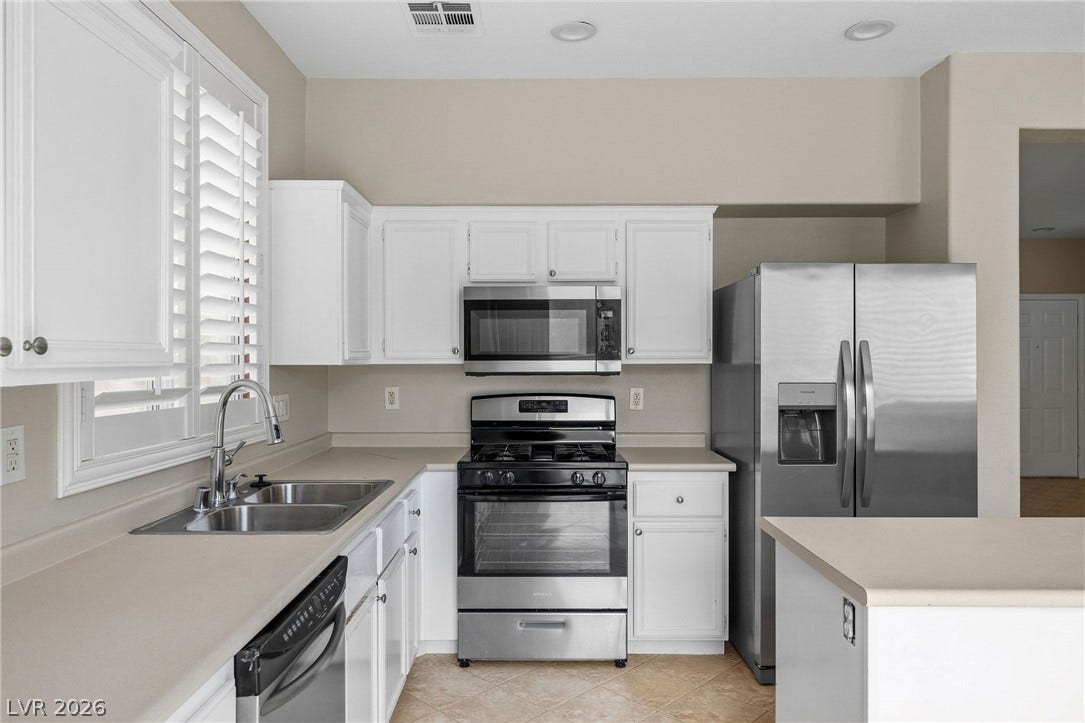 2381 Predera Avenue, Henderson, NV 89052 Gleaming stainless steel appliances complement classic white cabinetry and crisp plantation shutters.