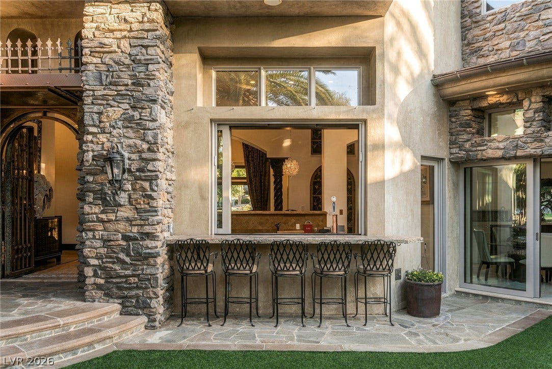 1513 Foothills Village Drive, Henderson, NV 89012 An outdoor bar counter sits seamlessly beneath a pass-through window framed by rustic stone cladding.
