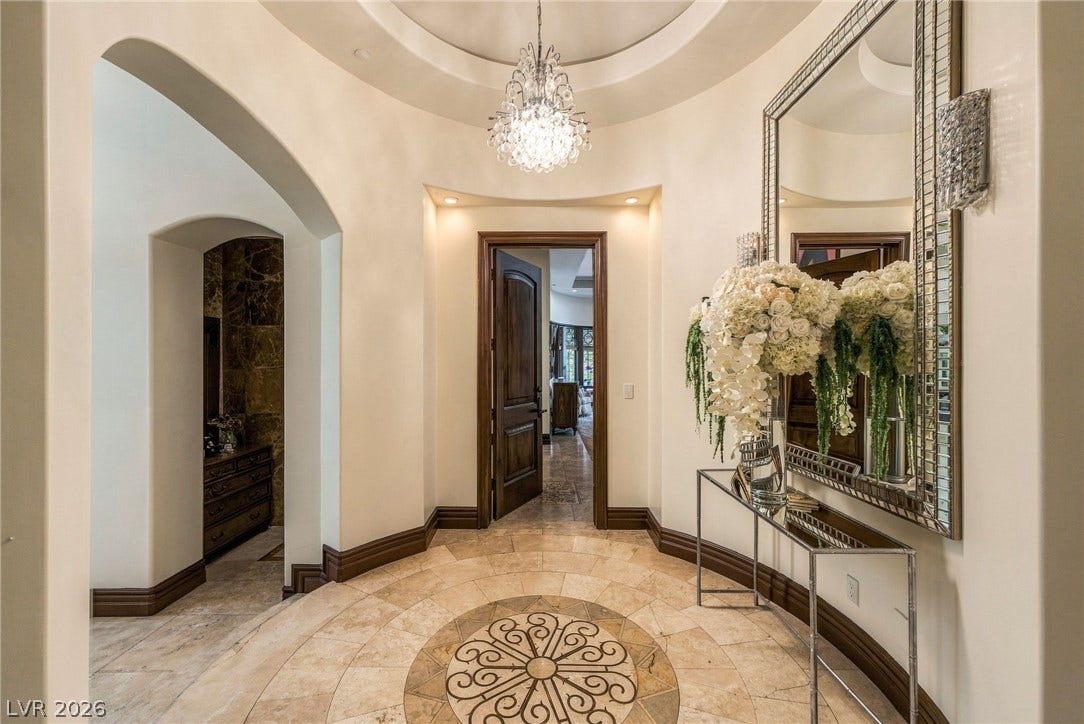 1513 Foothills Village Drive, Henderson, NV 89012 An elegant circular entry features a rotunda ceiling, detailed tile inlay, and arched passages.