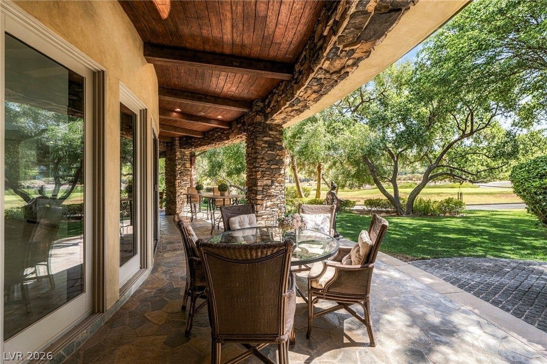 1513 Foothills Village Drive, Henderson, NV 89012 Stone pillars and a rich wood ceiling frame this covered patio overlooking the manicured grounds.