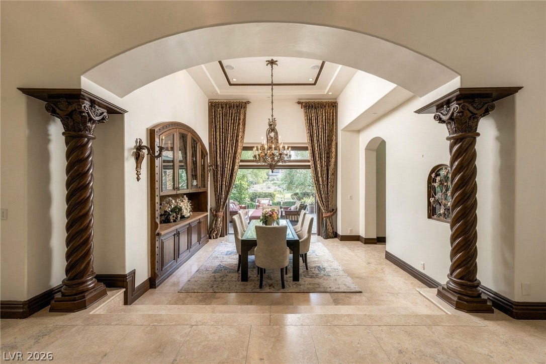 1513 Foothills Village Drive, Henderson, NV 89012 Ornate columns and a grand archway frame a formal dining room with tray ceilings.