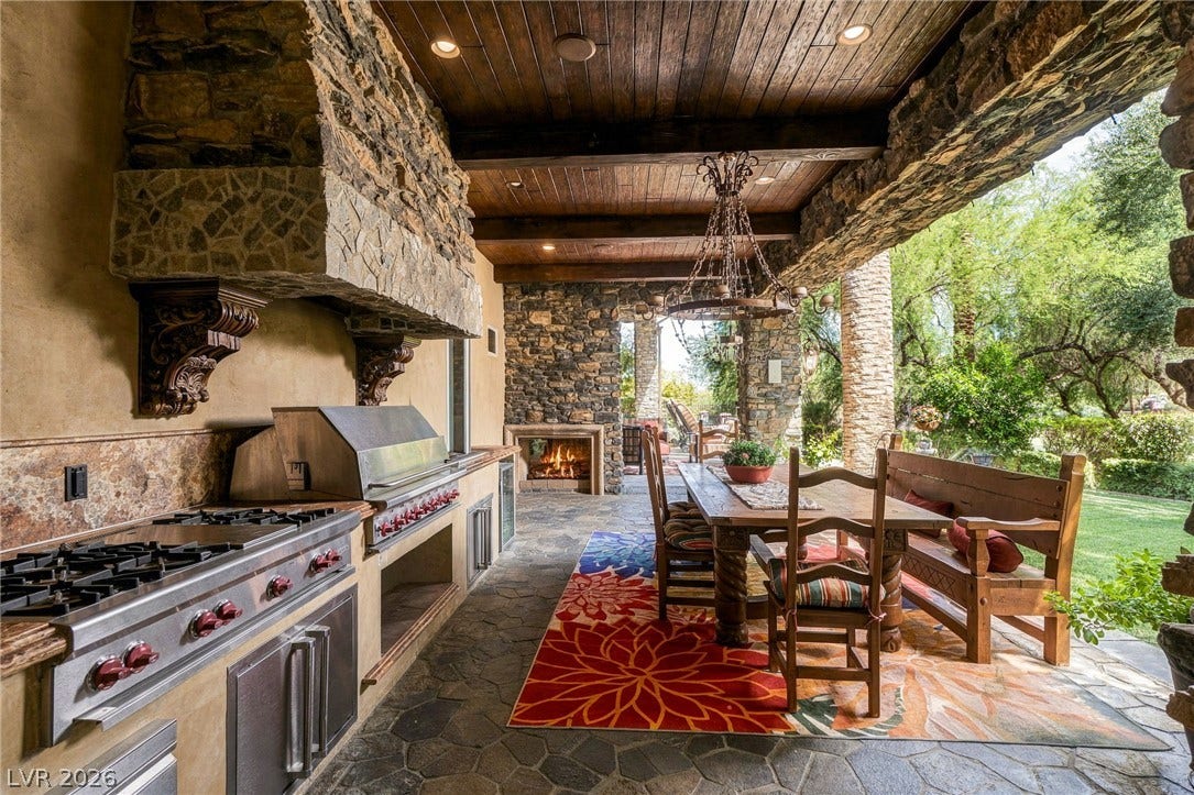 1513 Foothills Village Drive, Henderson, NV 89012 Stone accents and a wood-lined ceiling elevate this covered outdoor kitchen and dining area.