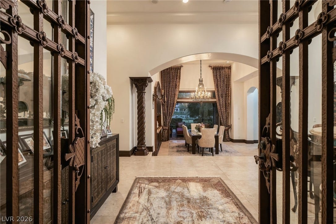 1513 Foothills Village Drive, Henderson, NV 89012 Ornate iron doors open into an elegant foyer with tiled flooring and classical architectural details.