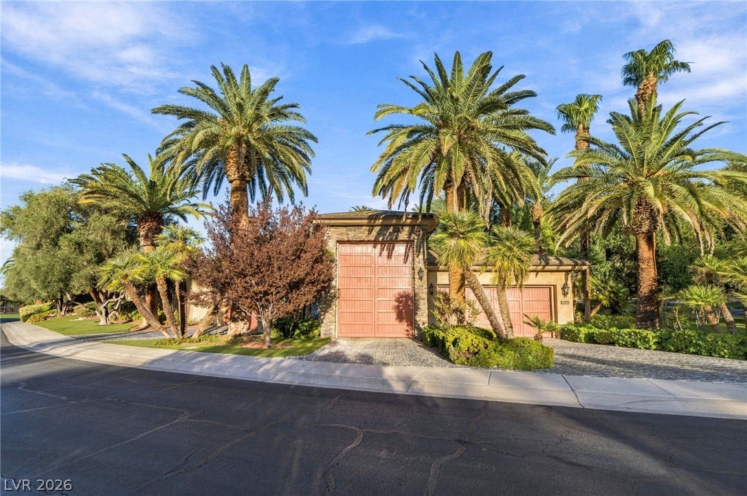 1513 Foothills Village Drive, Henderson, NV 89012 Lush palm trees frame the exterior of this estate featuring an oversized garage.