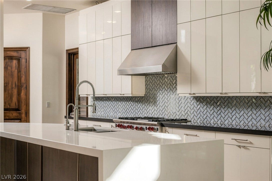 1513 Foothills Village Drive, Henderson, NV 89012 Glossy modern cabinetry and a tiled herringbone backsplash define this contemporary culinary space.