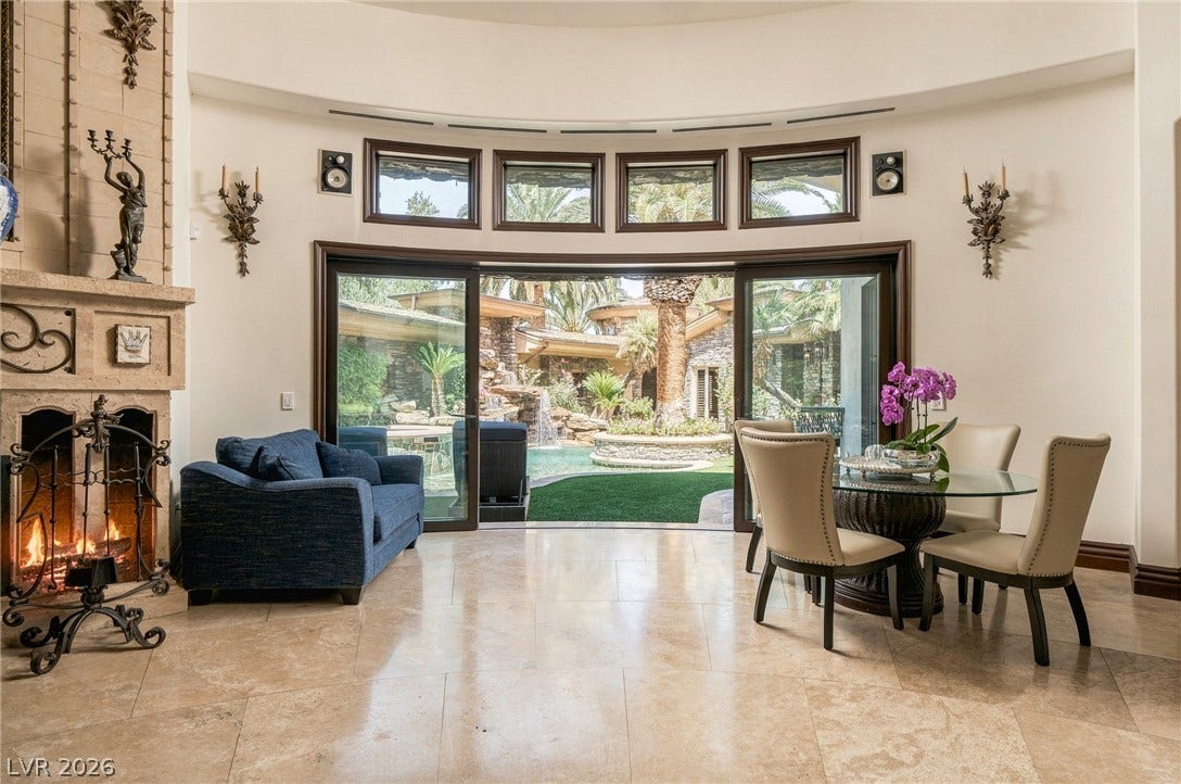 1513 Foothills Village Drive, Henderson, NV 89012 Polished tile flooring and a grand fireplace frame views of the pool courtyard.
