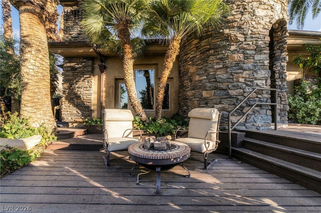 1513 Foothills Village Drive, Henderson, NV 89012 Natural stone masonry and wooden decking frame this inviting outdoor fire pit area.