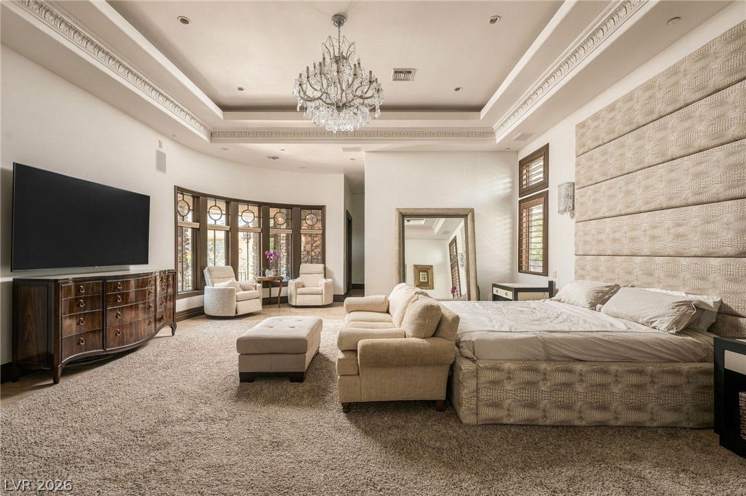 1513 Foothills Village Drive, Henderson, NV 89012 An elegant tray ceiling with crown molding and a crystal chandelier highlights this main suite.