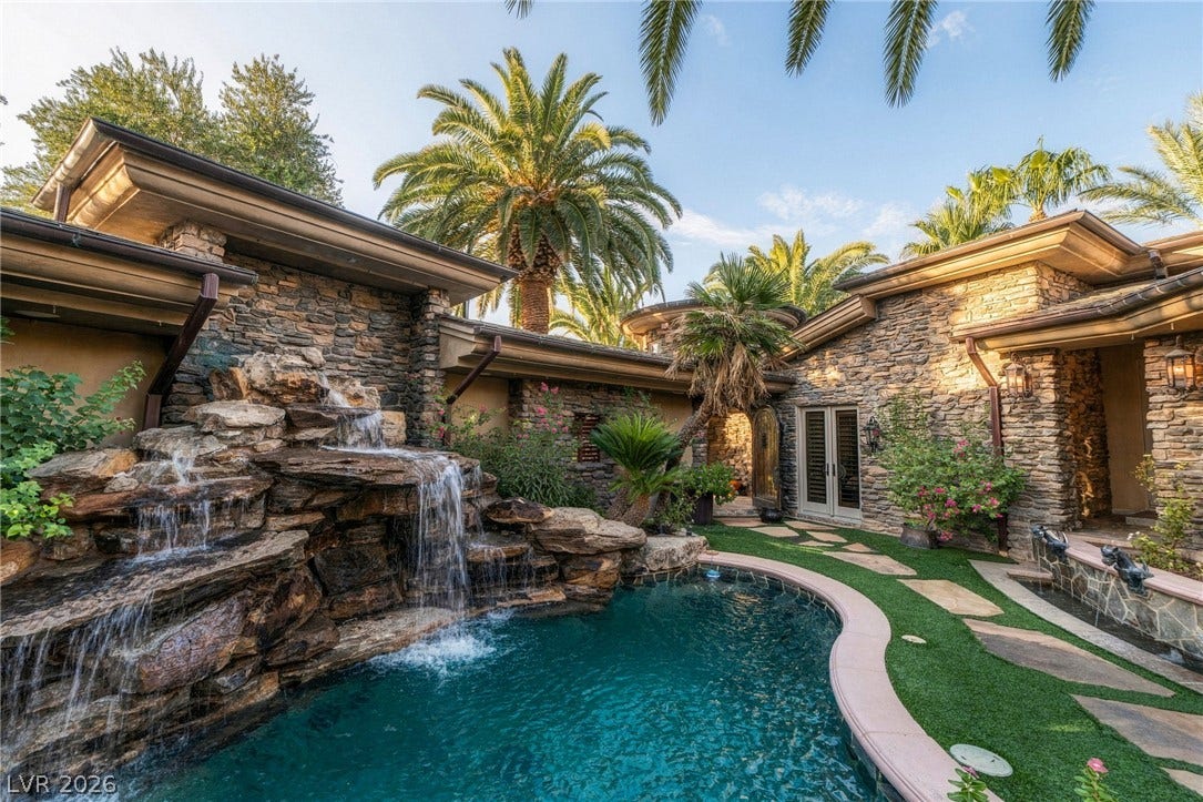 1513 Foothills Village Drive, Henderson, NV 89012 A natural stone waterfall cascades into a sparkling custom pool within a private courtyard oasis.