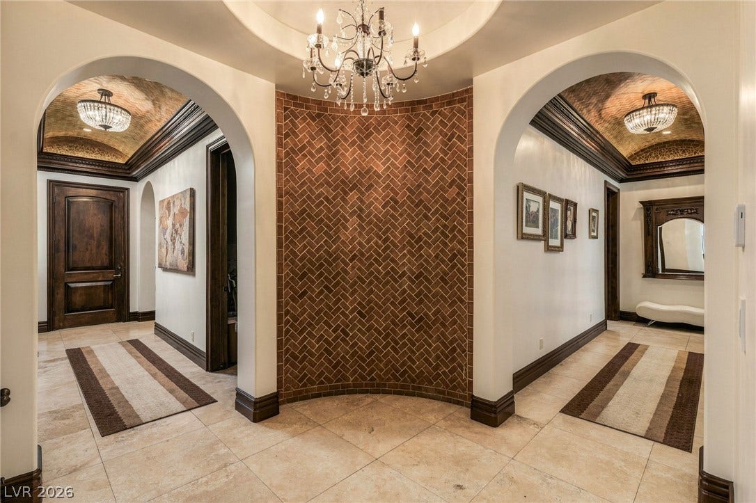 1513 Foothills Village Drive, Henderson, NV 89012 Elegant arched entryways frame barrel-vaulted ceilings and a central brick accent wall.