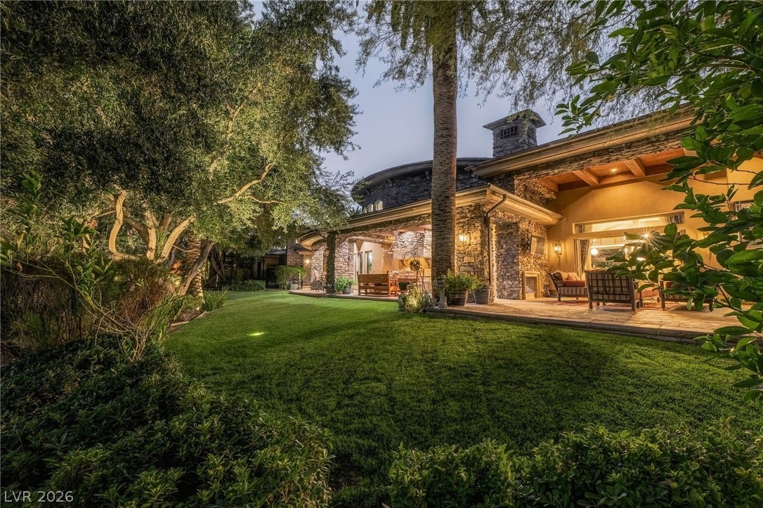 1513 Foothills Village Drive, Henderson, NV 89012 A manicured lawn and stone accents frame this exterior, which opens to a covered patio.
