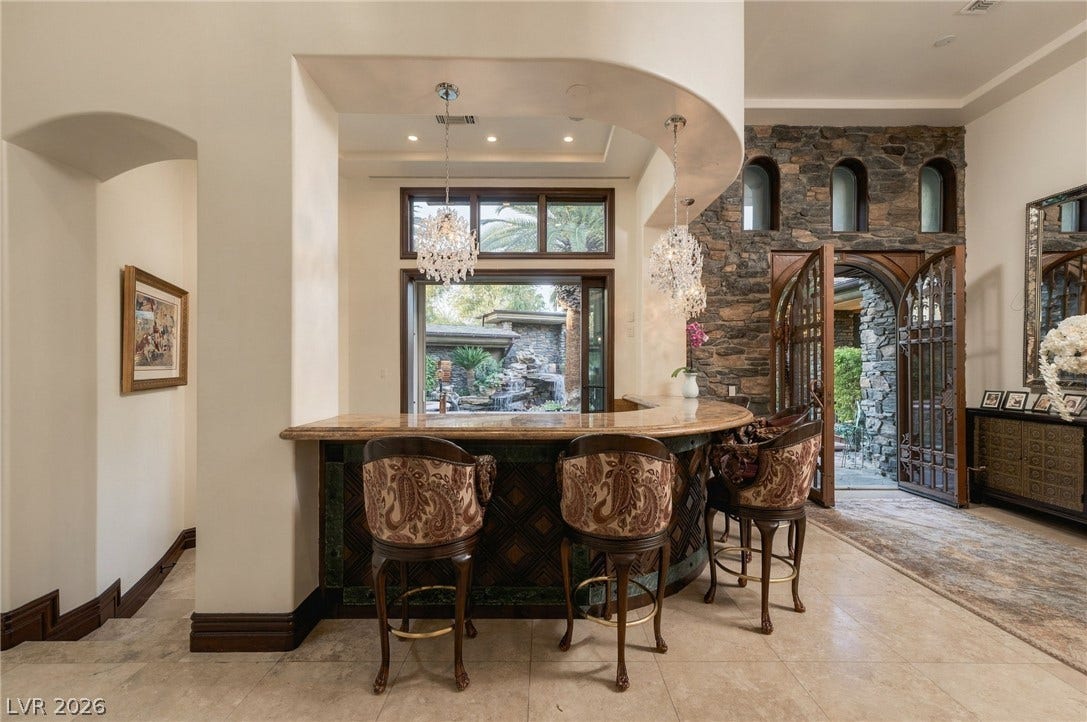 1513 Foothills Village Drive, Henderson, NV 89012 An elegant home bar features stone accents and a curved counter near the entrance.