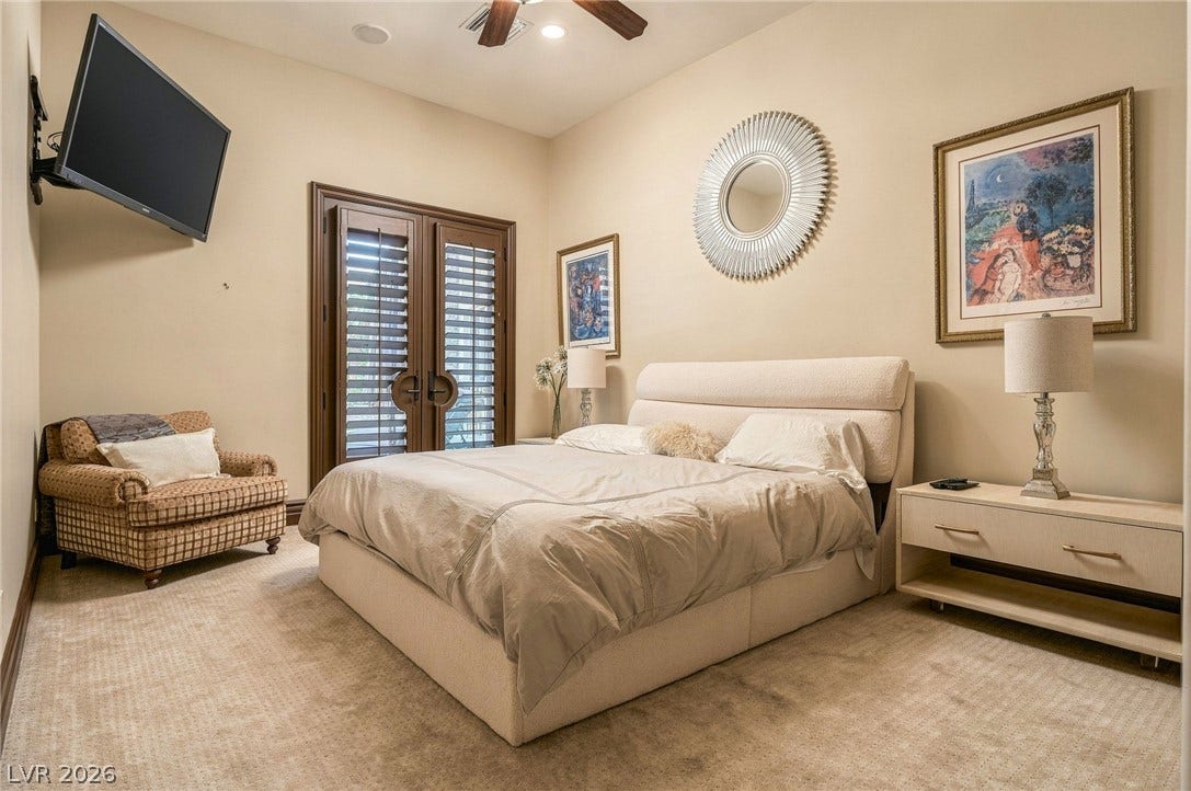 1513 Foothills Village Drive, Henderson, NV 89012 An elegant bedroom offers classic carpeting and handsome french doors leading outside.
