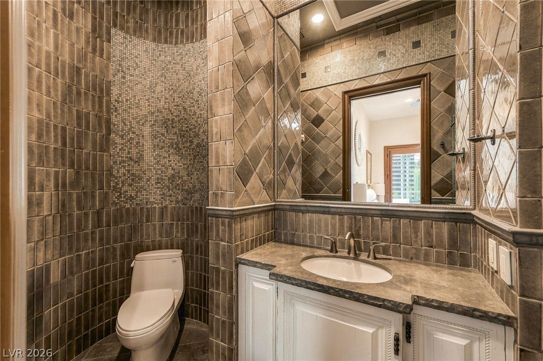 1513 Foothills Village Drive, Henderson, NV 89012 Ornate custom tilework and stone counters define this exquisitely detailed powder room.