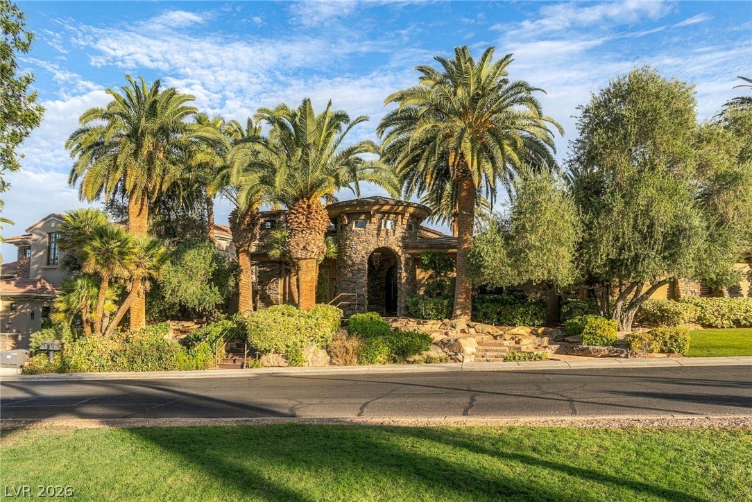 1513 Foothills Village Drive, Henderson, NV 89012 Lush tropical palm trees frame a grand stone turret entryway on this custom estate.