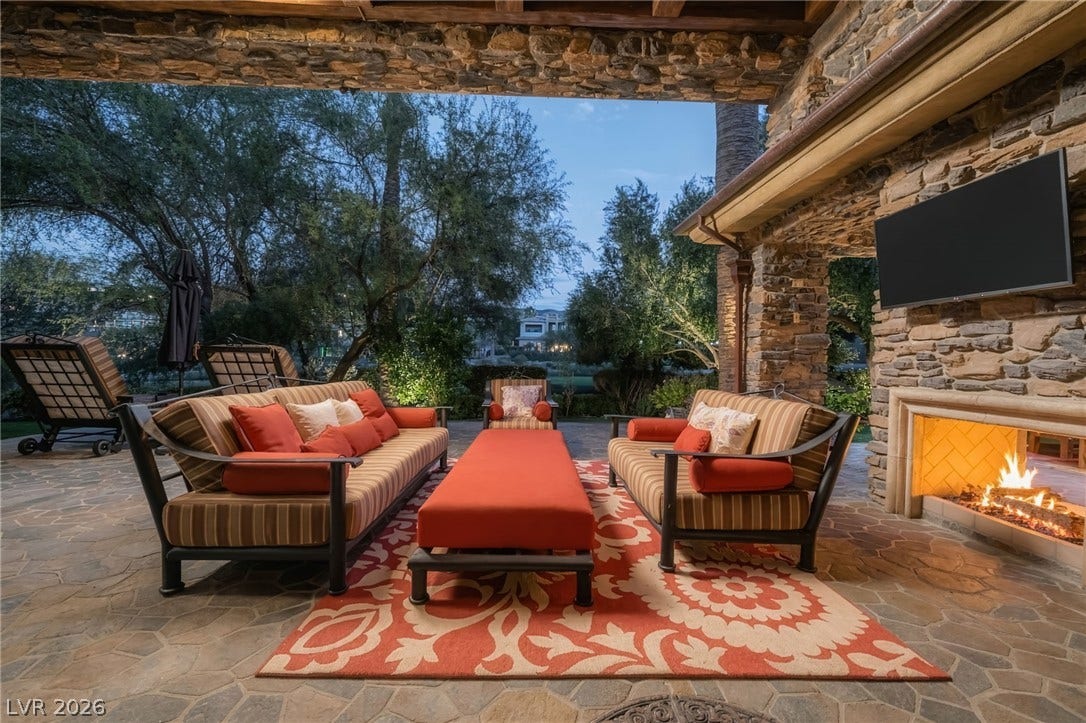 1513 Foothills Village Drive, Henderson, NV 89012 Stone walls and a warm fireplace define this covered outdoor living space.