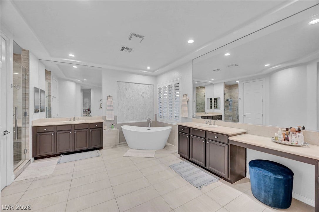 A spacious primary bathroom, freestanding soaking tub, separate shower and dual sinks