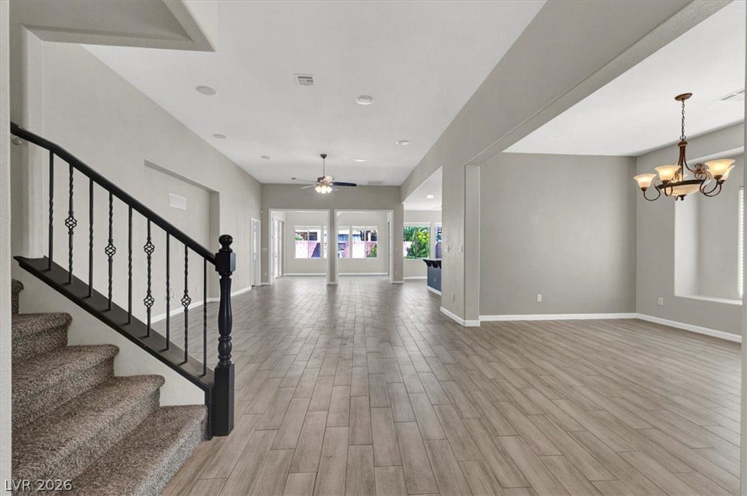 Clean lines and wood-look flooring define this open layout under soaring high ceilings.