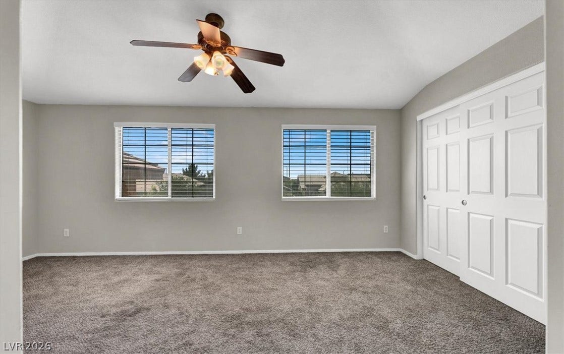 Plush carpeting and dual windows bring comfort to this versatile secondary bedroom space.