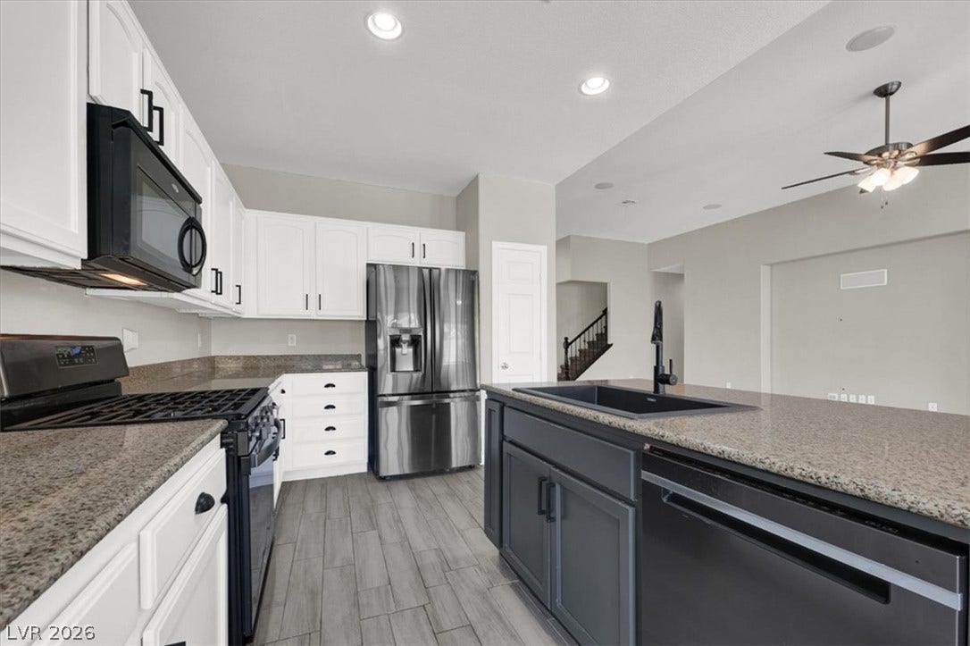Granite countertops and an expansive island anchor this modern kitchen with sleek tile flooring.