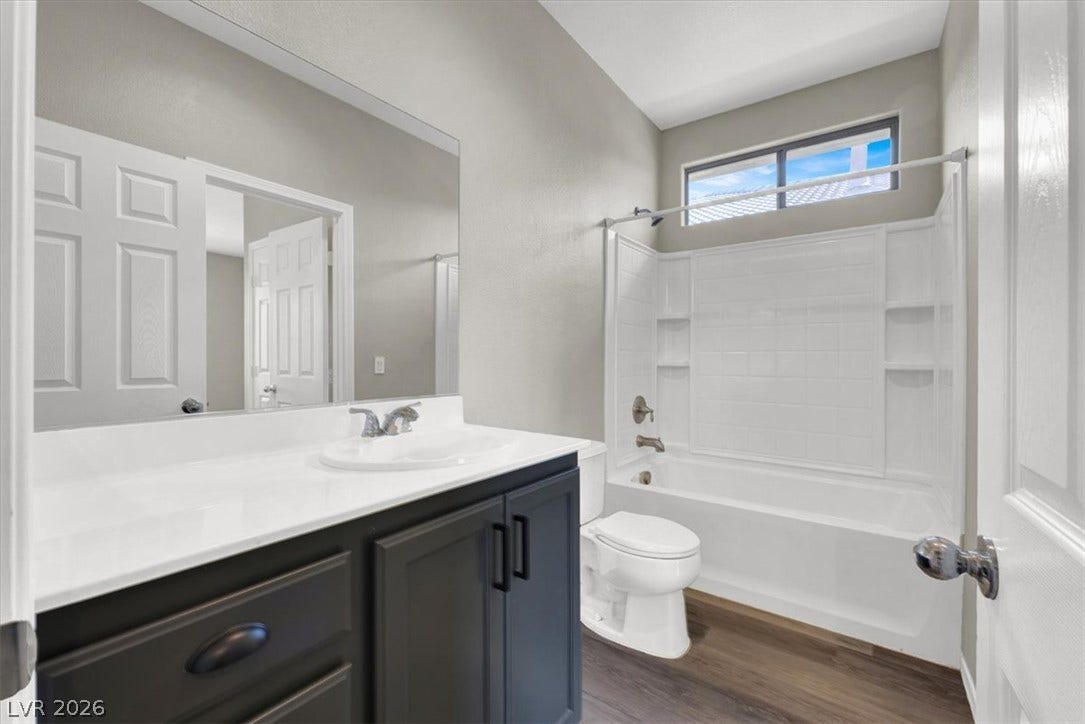 Clean lines and a high transom window define this modern, comfortable bathroom space.