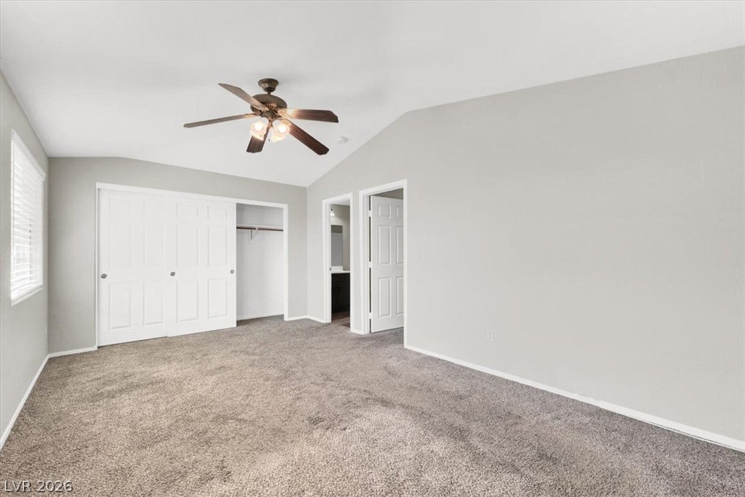 Plush carpeting and vaulted ceilings enhance this serene main bedroom.