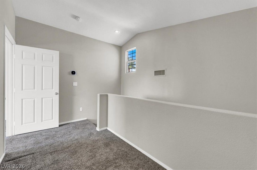 Plush carpeting and a half-wall partition detail this versatile upper-level landing space.
