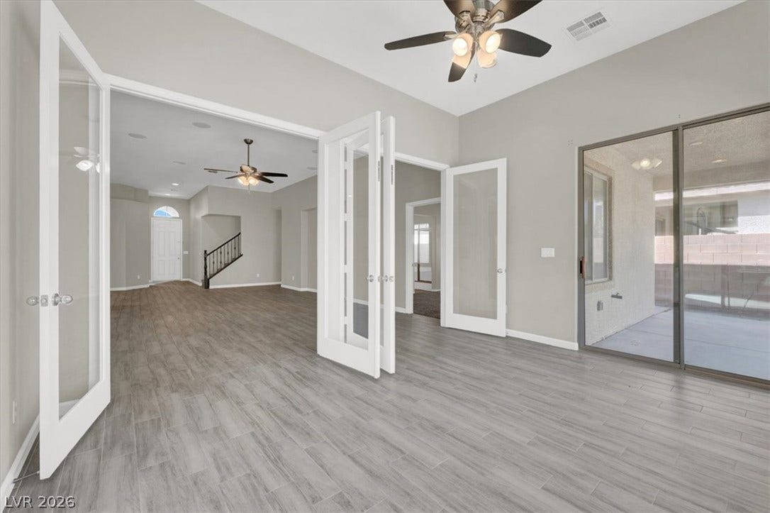 Classic French doors open to an airy layout complete with stylish wood-look flooring.