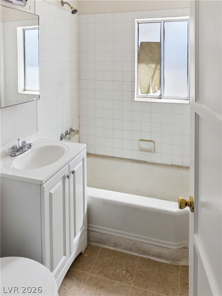 107 W Victory Road, Henderson, NV 89015 A classic bathtub and white vanity define this simple bathroom setup.